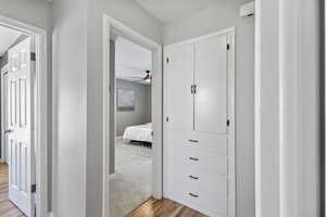 Corridor featuring light wood-style floors and baseboards