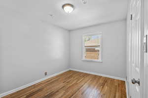 Unfurnished room featuring baseboards and wood finished floors