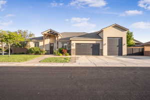 View of front facade featuring an attached garage, stucco siding, concrete driveway, a tiled roof, and stone siding