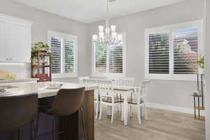 Dining area with a chandelier, light wood-type flooring, and plenty of natural light