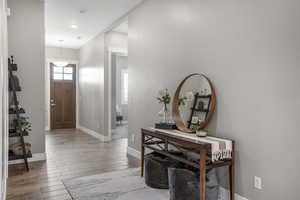 Foyer entrance with wood finished floors and baseboards