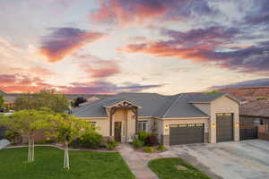View of front of house with a garage, driveway, stucco siding, stone siding, and a tiled roof