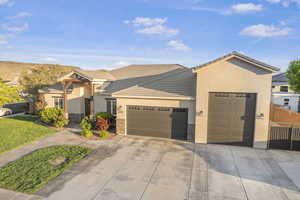 View of front facade with stone siding, a garage, stucco siding, concrete driveway, and a tiled roof