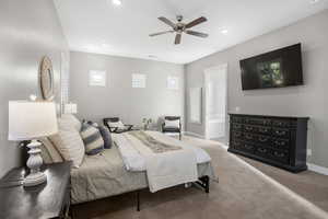 Bedroom featuring carpet, baseboards, ensuite bath, multiple windows, and recessed lighting