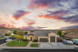 View of front of house with a garage, concrete driveway, stucco siding, and a tile roof