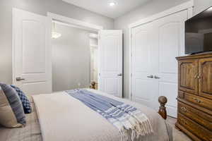 Bedroom featuring a closet, light carpet, and recessed lighting