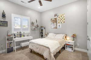 Carpeted bedroom with baseboards and a ceiling fan