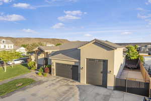 View of front of house featuring an attached garage, a tiled roof, stucco siding, driveway, and a mountain view