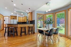 Dining area with recessed lighting, light wood-style flooring, and vaulted ceiling