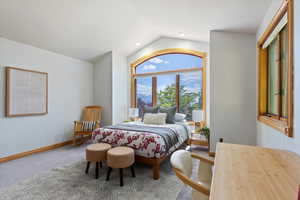 Bedroom with vaulted ceiling, carpet floors, and baseboards