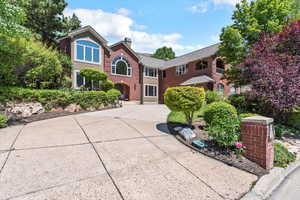 Traditional-style house with concrete driveway, a chimney, and brick siding