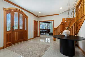 Entrance foyer with stairway, baseboards, ornamental molding, and recessed lighting