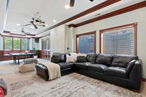 Living room featuring a ceiling fan and crown molding