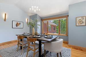 Dining area with baseboards, lofted ceiling, and light wood-style flooring