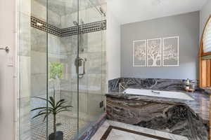 Full bathroom featuring a bath, inlaid floor details, and a stall shower
