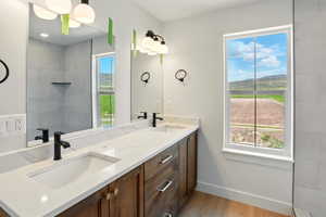Bathroom with plenty of natural light, wood finished floors, baseboards, and double vanity