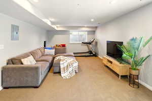 Carpeted living room featuring electric panel, recessed lighting, and baseboards