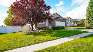 View of front of house with an attached garage, asphalt driveway, and brick siding