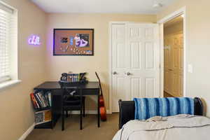 Bedroom featuring carpet and baseboards