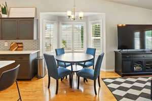 Dining room with a chandelier, light wood-style floors, and baseboards