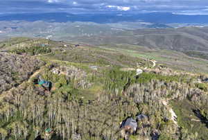 Aerial view of property and surrounding area with a mountainous background