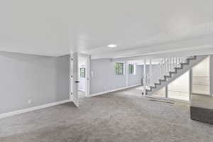 Basement with stairs, baseboards, and carpet flooring