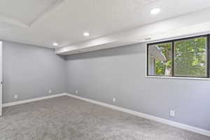 Basement featuring carpet, recessed lighting, a textured ceiling, and baseboards