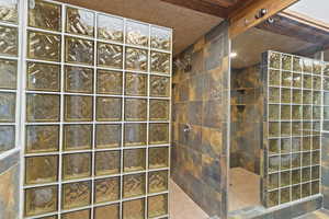 Bathroom with a walk in shower and tile walls