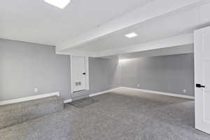 Finished below grade area with carpet flooring and baseboards