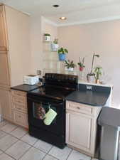 Kitchen with black range with electric cooktop, light tile patterned flooring, dark countertops, and recessed lighting