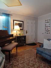 Sitting room featuring wood finished floors and crown molding