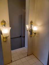Bathroom with tile patterned floors and a chandelier