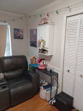 Living area with ornamental molding and light wood-style floors