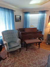 Living area featuring crown molding and wood finished floors