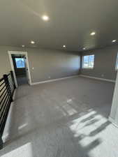 Carpeted empty room with recessed lighting and baseboards