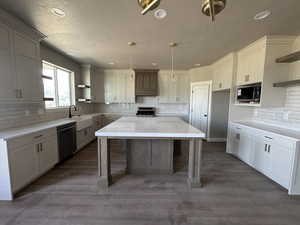 Kitchen featuring open shelves, stainless steel range, dishwasher, built in microwave, and a sink