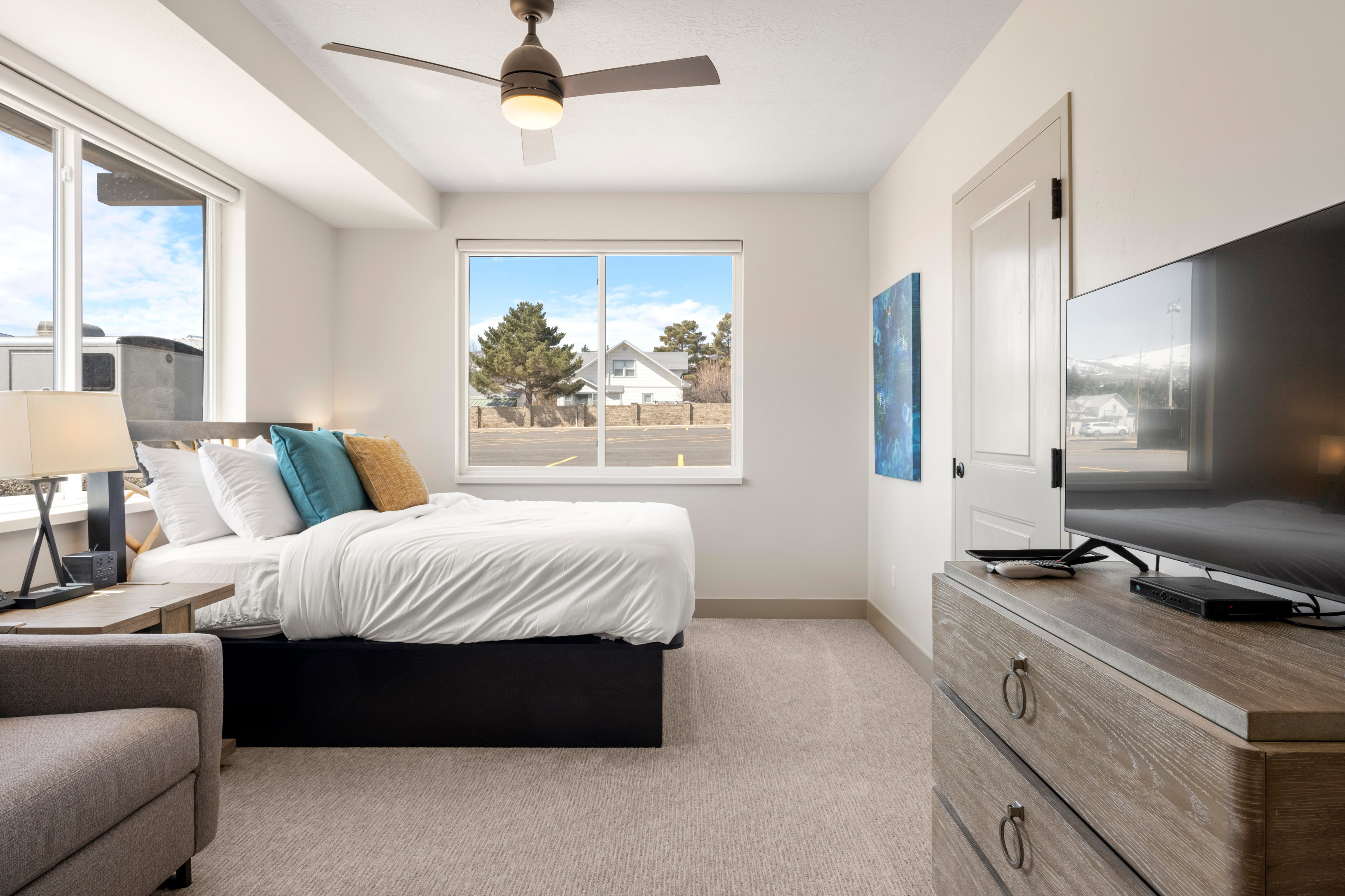 Bedroom with baseboards, light colored carpet, and a ceiling fan