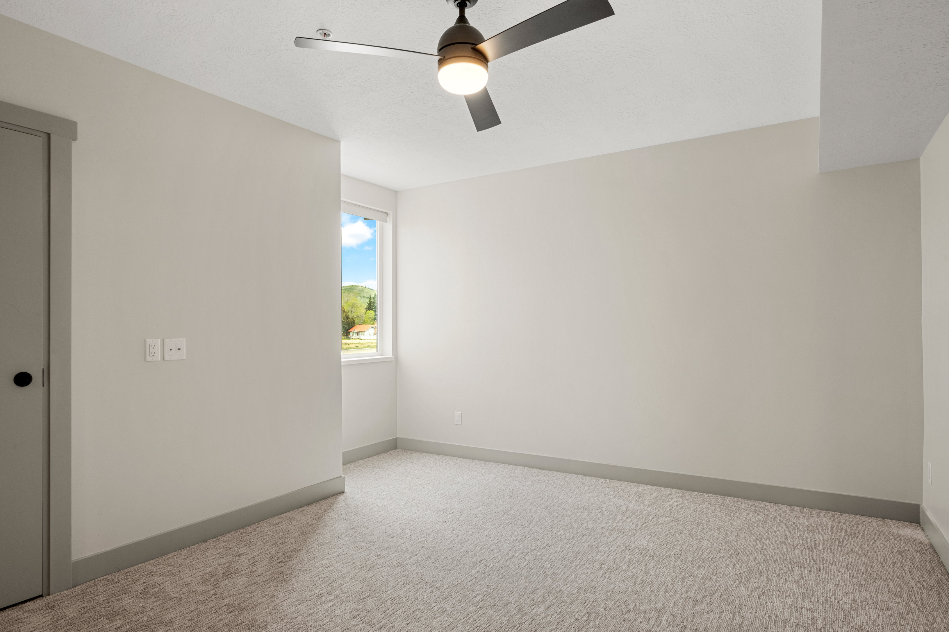 Spare room featuring carpet floors, ceiling fan, and baseboards