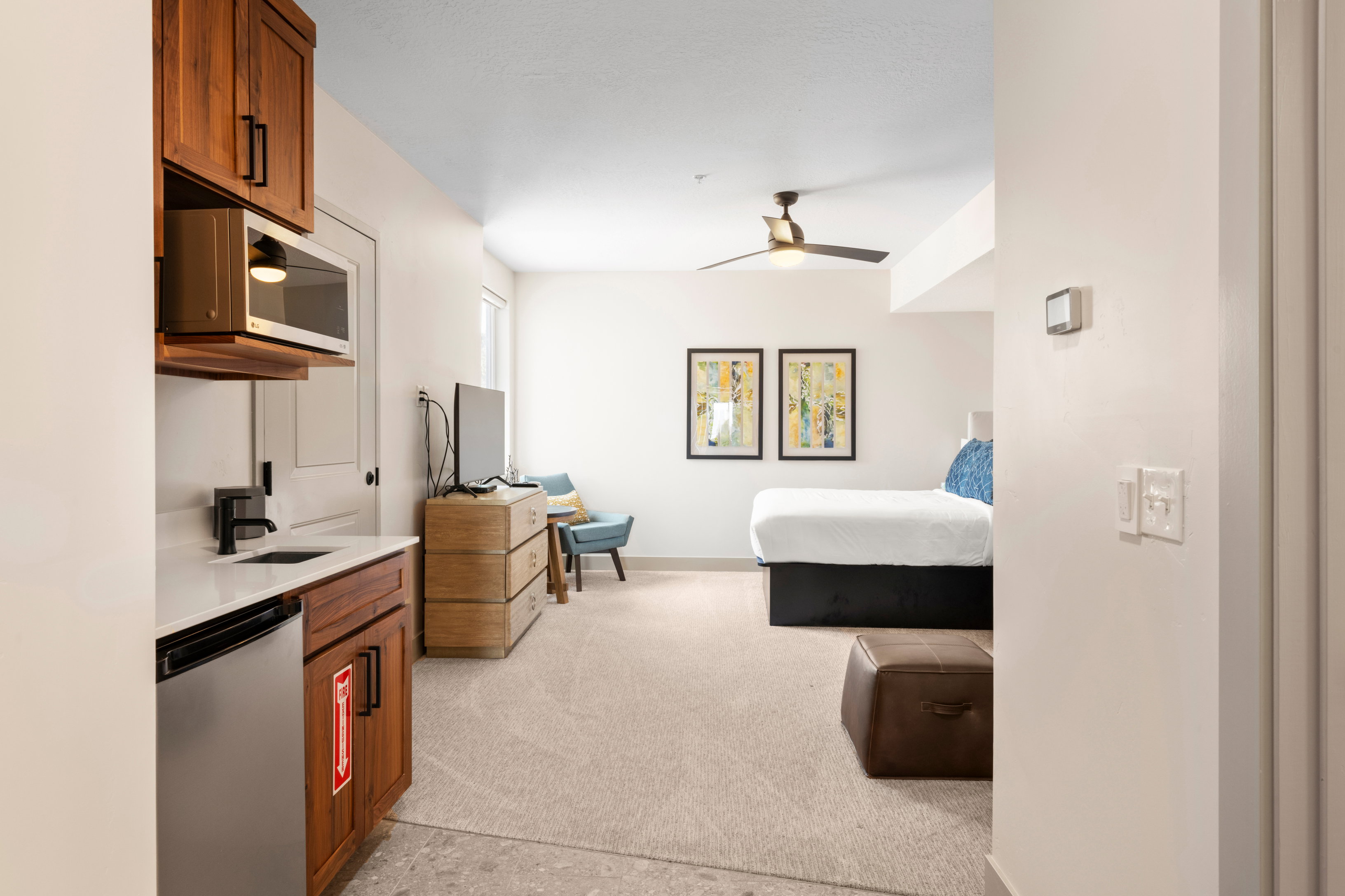 Bedroom featuring light carpet, a sink, and baseboards