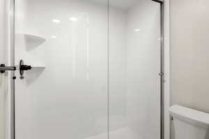 Bathroom featuring toilet and a shower stall