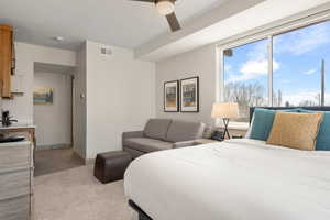 Bedroom featuring light colored carpet, ceiling fan, and baseboards
