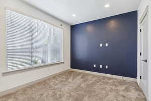 Carpeted empty room featuring recessed lighting and baseboards