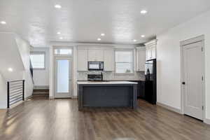 Kitchen with black appliances, baseboards, healthy amount of natural light, and recessed lighting