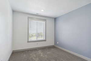 Carpeted spare room with baseboards