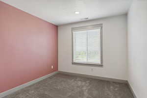 Carpeted empty room featuring baseboards and recessed lighting