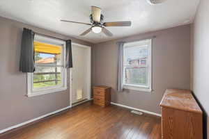 Unfurnished bedroom featuring baseboards, hardwood / wood-style flooring, and a ceiling fan