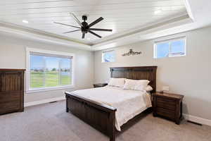 Bedroom with a raised ceiling, baseboards, light colored carpet, and recessed lighting
