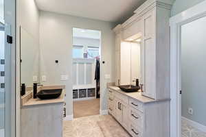 Bathroom with two vanities, baseboards, and recessed lighting
