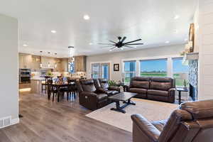 Living room featuring light wood-style floors, recessed lighting, a ceiling fan, and a fireplace
