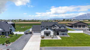View of front of home featuring concrete driveway, stone siding, a standing seam roof, a mountain view, and metal roof